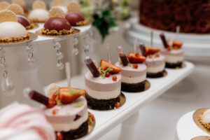 Delicious mousse desserts decorated with strawberries at the banquet candy bar